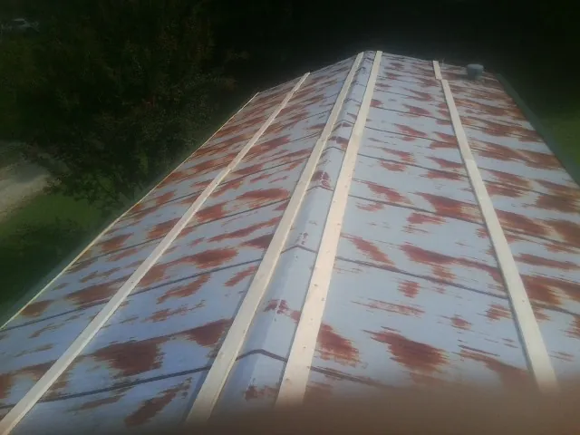 Rusted metal roof panels with new wood purlins before replacement — Storm Damage Roof Repair in Clemons by Roofing Brothers