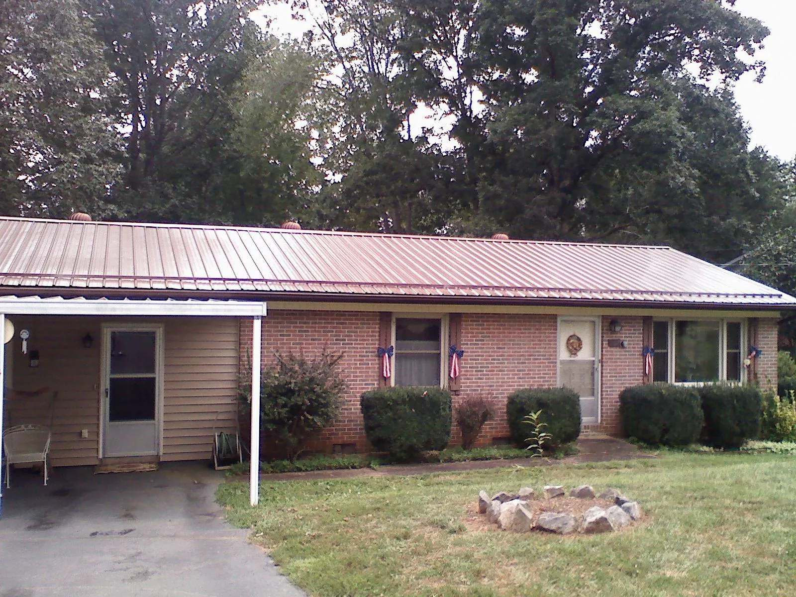 Bronze metal roof and carport on a brick ranch home — Roof Repair work by our crew in Clemons